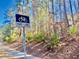 Bike lane sign with bushes and trees in the background indicates an exercise-friendly neighborhood at 211 Providence Glen, Chapel Hill, NC 27514