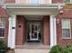 Covered doorway with white pillars and brick facade at Building 200 offers a welcoming entrance at 211 Providence Glen, Chapel Hill, NC 27514