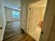 Hallway shows access to the main bedroom with laminate wood flooring and neutral paint at 211 Providence Glen, Chapel Hill, NC 27514