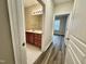 Hallway view of bathroom vanity with wood cabinets and a view to a bedroom at 211 Providence Glen, Chapel Hill, NC 27514