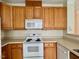A cozy kitchen featuring wooden cabinets, modern appliances and tile flooring at 211 Providence Glen, Chapel Hill, NC 27514