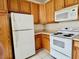 A functional kitchen featuring wooden cabinets, white appliances and a microwave at 211 Providence Glen, Chapel Hill, NC 27514