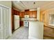 Bright kitchen features white appliances, hardwood cabinets, and a tiled floor at 211 Providence Glen, Chapel Hill, NC 27514