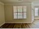 A cozy living room showcasing hardwood floors and a window with horizontal blinds at 211 Providence Glen, Chapel Hill, NC 27514