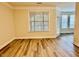 An open living room showcasing hardwood floors, a large window, and entry to another room at 211 Providence Glen, Chapel Hill, NC 27514