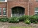 Brick porch with bushes surrounding is shaded and offers a cozy and private entrance at 211 Providence Glen, Chapel Hill, NC 27514