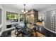 Stylish dining area with glass table, modern lighting, stone accent wall and outdoor views at 2207 Vintage Hill Dr, Durham, NC 27712