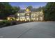 Luxury home featuring stone accents and ample parking on a large driveway with lush landscaping at 2207 Vintage Hill Dr, Durham, NC 27712