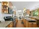 Bright kitchen featuring wood cabinets, granite countertops, stainless steel appliances, and brick flooring at 2306 Damascus Church Rd, Chapel Hill, NC 27516
