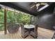 A covered deck with wicker furniture, perfect for outdoor dining surrounded by lush trees at 2306 Damascus Church Rd, Chapel Hill, NC 27516