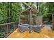 A serene outdoor space with comfortable seating within a wood-framed pergola surrounded by lush greenery at 2306 Damascus Church Rd, Chapel Hill, NC 27516