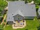 Aerial view of backyard with a stone patio, fire pit, and screened-in porch at 2419 Rogerson St, Raleigh, NC 27614