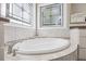 Close-up of the soaking tub in the main bathroom, showcasing decorative tiling and a modern faucet at 2419 Rogerson St, Raleigh, NC 27614