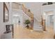 Grand foyer with staircase featuring wood railing, carpeted steps, and views to entry and living areas at 2419 Rogerson St, Raleigh, NC 27614