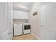 Laundry room featuring a washer and dryer, white cabinets, and a door to the side at 2419 Rogerson St, Raleigh, NC 27614