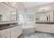 Elegant main bathroom featuring dual vanities, a soaking tub with decorative tiling, and decorative windows at 2419 Rogerson St, Raleigh, NC 27614