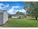 Expansive backyard with lush green lawn, wooden deck, and a storage shed, perfect for outdoor activities and storage at 2528 Barwick Dr, Durham, NC 27704