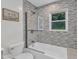 Stylish bathroom with modern fixtures, tiled walls, bathtub, and glass shower door at 2528 Barwick Dr, Durham, NC 27704