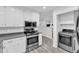 Modern kitchen with stainless steel appliances and sleek countertops, adjacent to laundry area at 2528 Barwick Dr, Durham, NC 27704