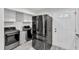 Convenient laundry room with stainless steel washer/dryer and a modern refrigerator at 2528 Barwick Dr, Durham, NC 27704