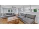 Well lit living room featuring hardwood floors, a large sectional sofa, and an open view to the entry and dining area at 2528 Barwick Dr, Durham, NC 27704