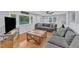 Bright living room with hardwood floors, a spacious gray sectional, and large windows that fill the space with natural light at 2528 Barwick Dr, Durham, NC 27704