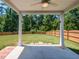Covered patio overlooking a spacious, fenced backyard with lush green lawn and mature trees at 2609 Kilmartin Dr, Fuquay Varina, NC 27526