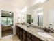 Bathroom vanity featuring granite countertops, double sinks, and a large mirror at 2609 Kilmartin Dr, Fuquay Varina, NC 27526