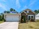 Charming single Gathering home with well-maintained landscaping, a two-car garage, and stone accents around the front door at 2609 Kilmartin Dr, Fuquay Varina, NC 27526