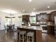 Spacious kitchen with granite countertops, an island with seating, stainless steel appliances, and an open layout to the dining area at 2609 Kilmartin Dr, Fuquay Varina, NC 27526