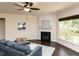 Comfortable living room featuring a fireplace, a large window, hardwood floors and a ceiling fan at 2609 Kilmartin Dr, Fuquay Varina, NC 27526
