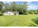 Two-story home with a spacious yard, balcony, and garage under the house, shaded by mature trees at 3012 Optimist Farm Rd, Apex, NC 27539