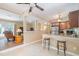 Open kitchen with granite countertops, stainless appliances, breakfast bar, ceiling fan and tile floors at 3012 Optimist Farm Rd, Apex, NC 27539
