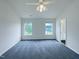Bright main bedroom featuring a ceiling fan, and two windows that provide natural light at 308 Quartz Dr, Durham, NC 27703