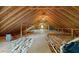 View of large unfinished attic space with wooden beams and subflooring at 311 Rassie Crabtree Rd, Rougemont, NC 27572