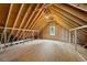 Attic with wooden beams, flooring and walls, plus a window for natural light at 311 Rassie Crabtree Rd, Rougemont, NC 27572