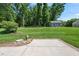 Spacious backyard featuring a concrete patio, surrounded by lush lawn and mature trees at 311 Rassie Crabtree Rd, Rougemont, NC 27572