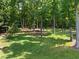 Secluded backyard featuring mature trees and a lush lawn, offering a peaceful outdoor space at 311 Rassie Crabtree Rd, Rougemont, NC 27572