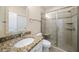 Well-lit bathroom with granite countertops, single sink, and shower with glass door at 311 Rassie Crabtree Rd, Rougemont, NC 27572