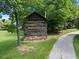 Exterior view of log cabin with rock foundation, wood pile, and gravel driveway at 311 Rassie Crabtree Rd, Rougemont, NC 27572