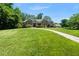 Beautiful home with a well-maintained lawn and stone facade, surrounded by lush greenery on a sunny day at 311 Rassie Crabtree Rd, Rougemont, NC 27572