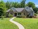 Charming single-story home with stone accents and a well-manicured lawn and paved walkway at 311 Rassie Crabtree Rd, Rougemont, NC 27572