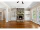 Living room featuring a stone fireplace, built-in shelving, and hardwood floors at 311 Rassie Crabtree Rd, Rougemont, NC 27572