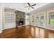 Cozy living room with fireplace, built-in bookshelves, hardwood floors, and backyard access at 311 Rassie Crabtree Rd, Rougemont, NC 27572