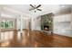 Spacious living room with hardwood floors, stone fireplace, built-in cabinets, and large windows at 311 Rassie Crabtree Rd, Rougemont, NC 27572