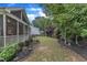 Beautiful landscaped backyard featuring lush greenery and garden, complemented by a screened porch and pathway at 3111 Virginia Pine Ln, Apex, NC 27539