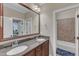 Bathroom with a double sink vanity and a large mirror, and featuring a tub-shower combo in the adjoining room at 3111 Virginia Pine Ln, Apex, NC 27539