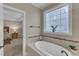 The bathroom features a soaking tub and stylish window, adjacent to the primary bedroom at 3111 Virginia Pine Ln, Apex, NC 27539