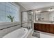 A luxurious bathroom features a soaking tub, glass-enclosed shower, and double vanity with granite countertops at 3111 Virginia Pine Ln, Apex, NC 27539
