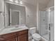 Bright bathroom featuring a glass enclosed shower, toilet, and a dark wood vanity at 3111 Virginia Pine Ln, Apex, NC 27539